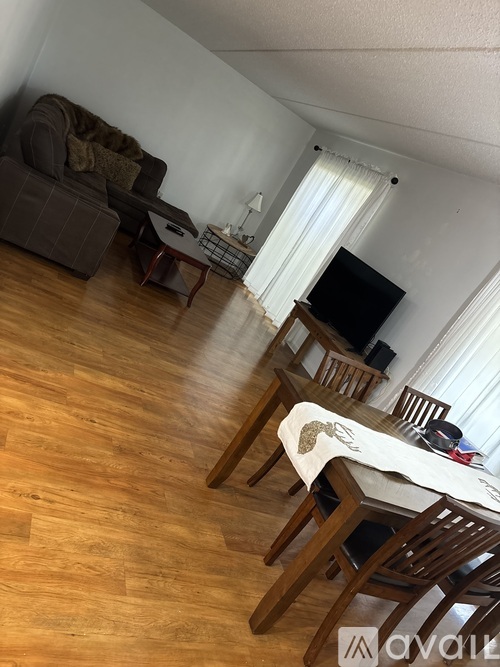 A living room with a couch, chairs, and a television.