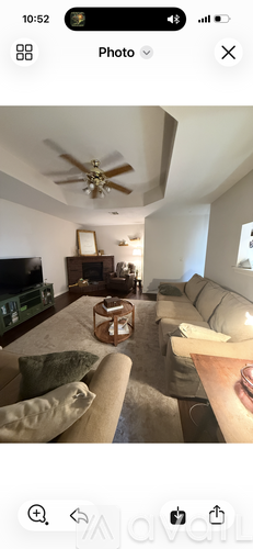 A living room with a beige sofa and a wooden coffee table.