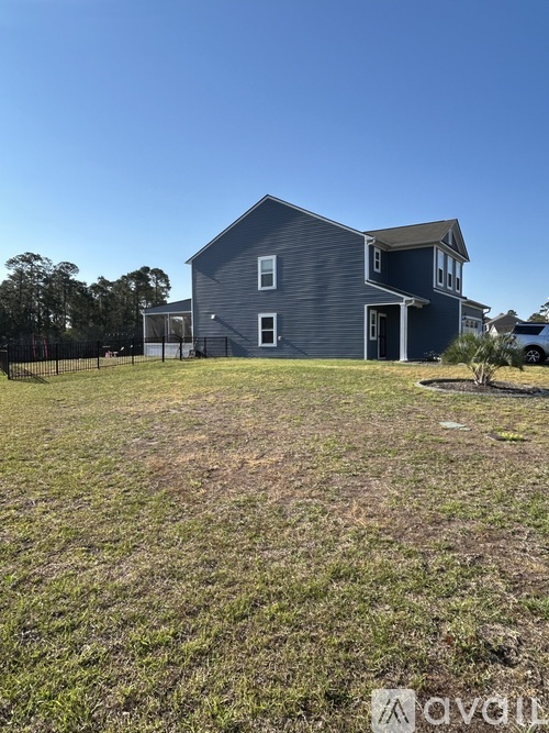 A house with a grey exterior is surrounded by a grassy area.