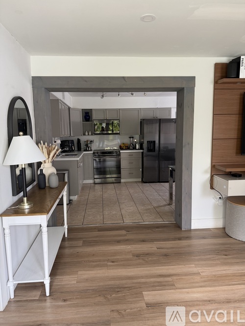 A kitchen with a white island and wooden floors.