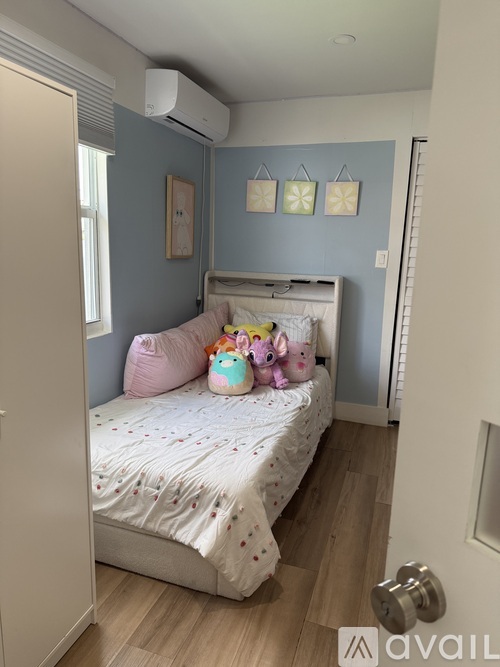 A bedroom with a bed, pillows, and toys.