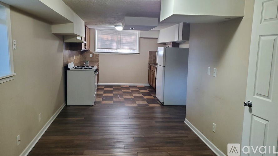 A kitchen area with a checkered floor and a refrigerator.