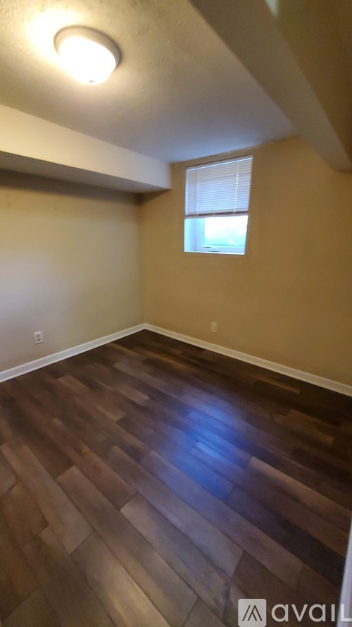 A room with wooden flooring and a window.