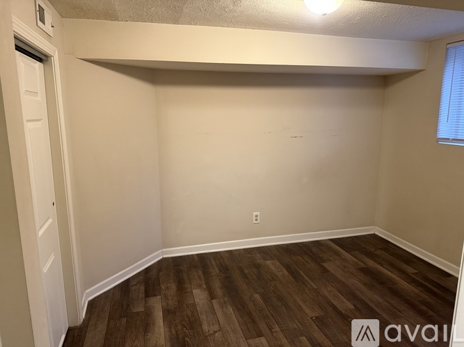A room with wooden flooring and white walls.