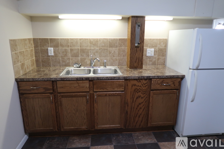 A kitchen with brown cabinets and a white refrigerator.
