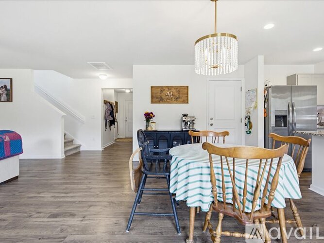 A dining room with a table set for four and a couch.