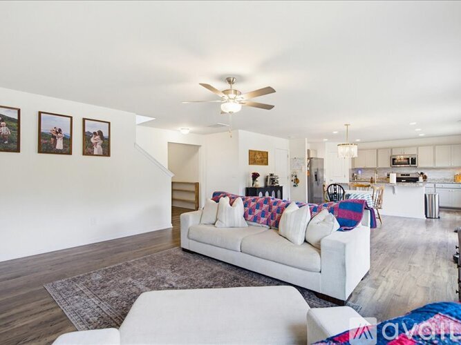 A living room with a white couch and a ceiling fan.