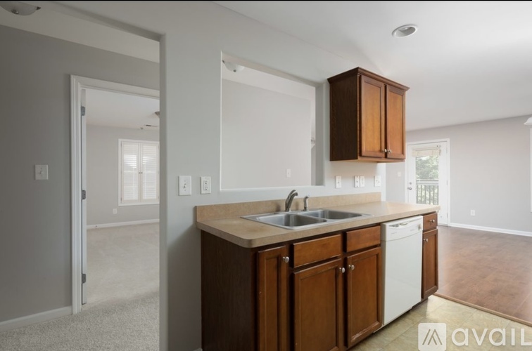 A kitchen with wooden cabinets and a white dishwasher.