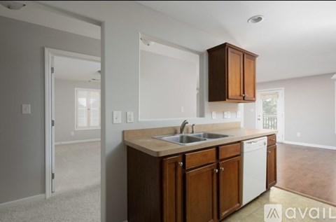 A kitchen with wooden cabinets and a white dishwasher.