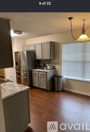 A kitchen with a refrigerator, stove, and cabinets.