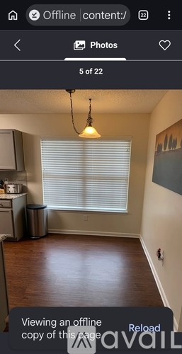 A room with a window covered by blinds and a hanging light fixture.