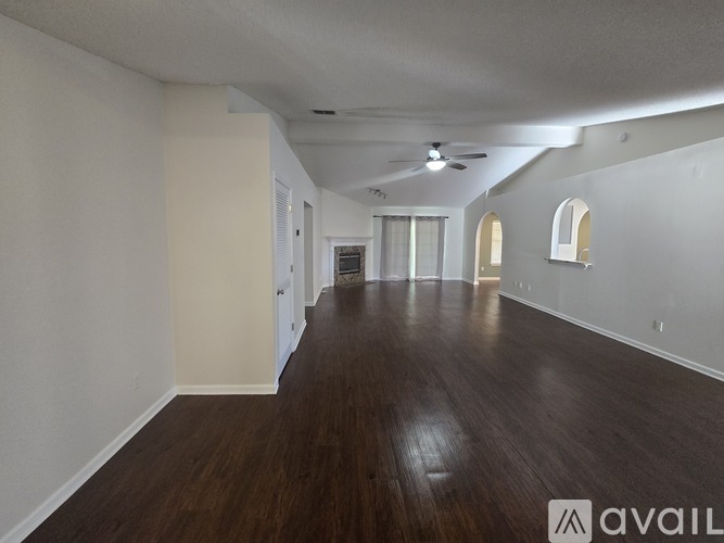 A spacious room with wooden floors and white walls.