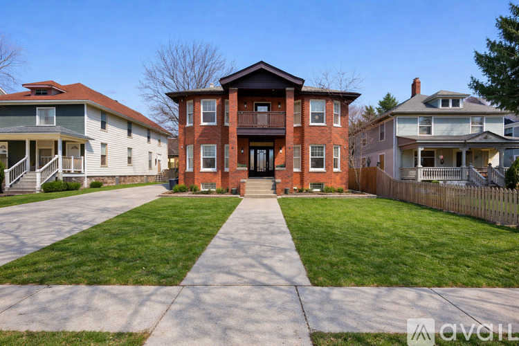 A red brick house with a green lawn in front.