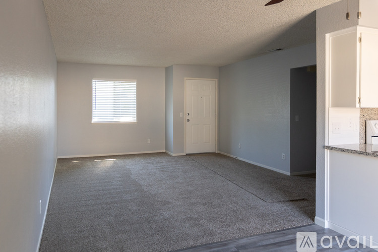 A room with a carpeted floor and a window with blinds.