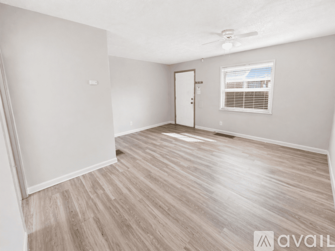 A room with a wooden floor and a ceiling fan.