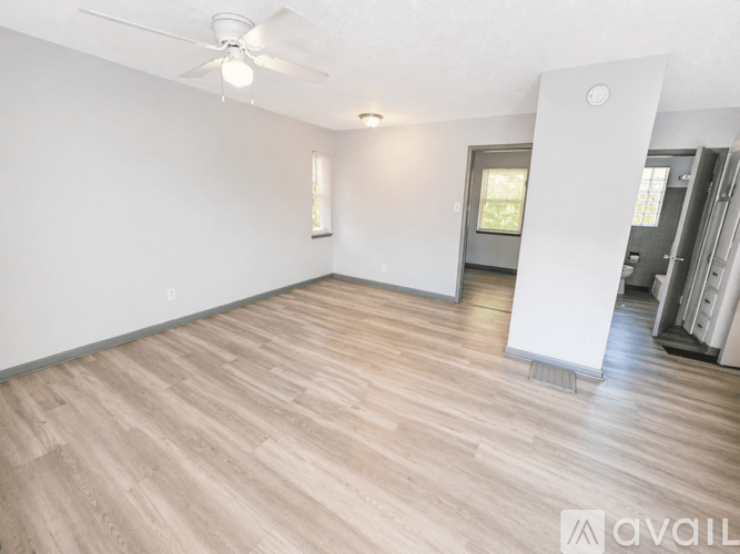 A room with wooden flooring and a ceiling fan.