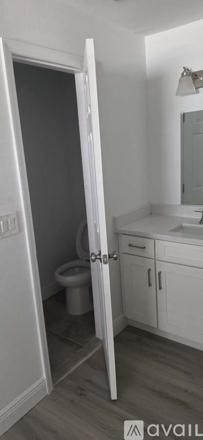 A bathroom with a toilet, sink, and mirror.