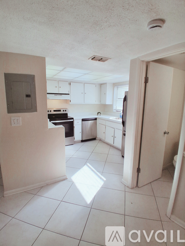 A kitchen with white cabinets and appliances is available for rent.