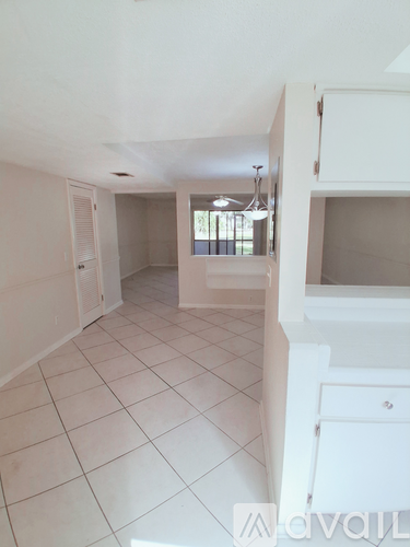 A white room with a kitchen area and a window.