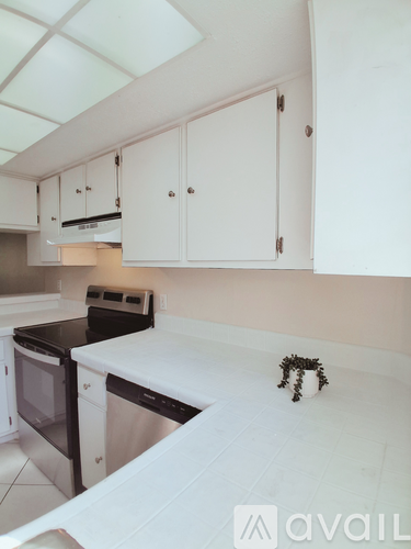 A kitchen with white cabinets and a black stove top.