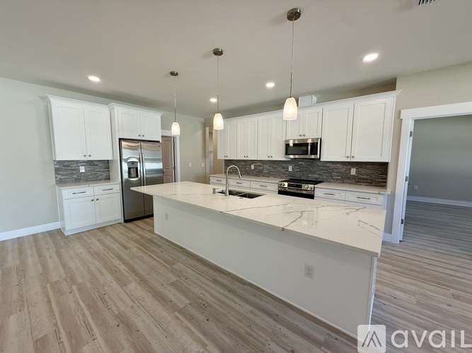 A kitchen with white cabinets and a marble countertop.