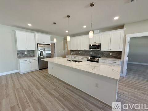 A kitchen with white cabinets and a marble countertop.