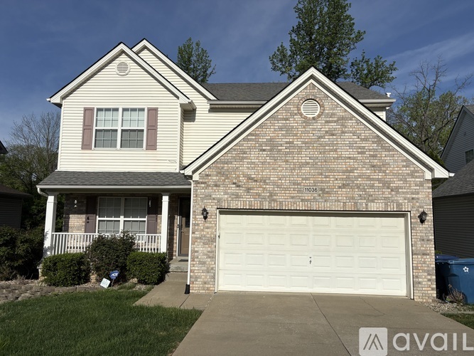 A two-story house with a garage and a driveway.