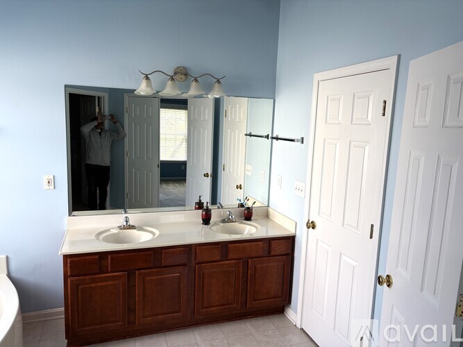 A bathroom with a double sink vanity and a large mirror.