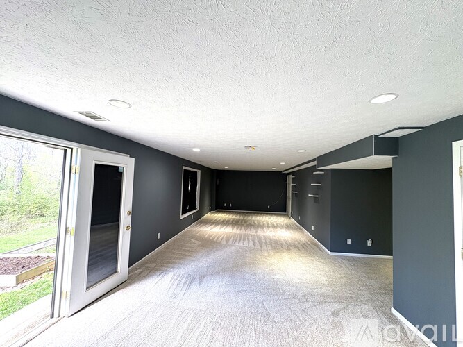 A spacious room with grey walls and a carpeted floor.
