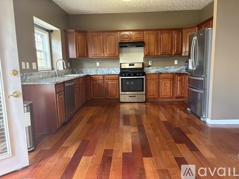 A kitchen with wooden cabinets and a refrigerator.