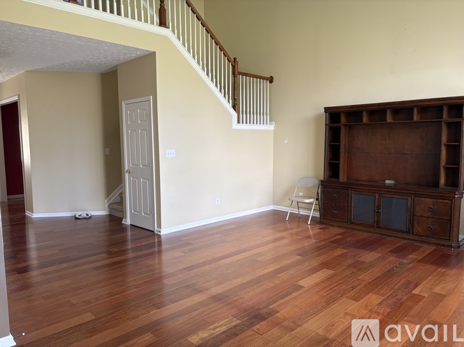 A living room with a wooden floor and a white chair.