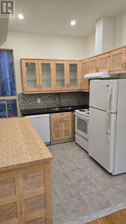 A kitchen with wooden cabinets and a white refrigerator.