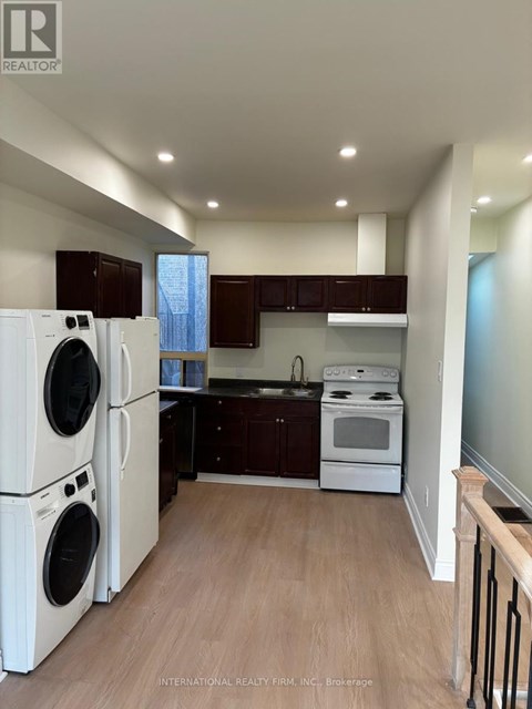 A kitchen with white appliances and wooden floors.