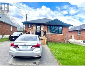 A silver car is parked in front of a brick house with a license plate that reads "CFJ-377".