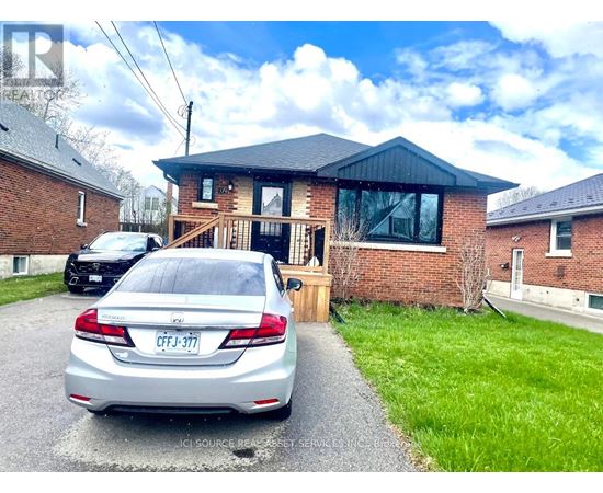 A silver car is parked in front of a brick house with a license plate that reads "CFJ-377".