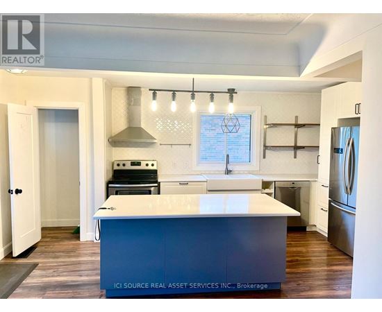A kitchen with a white island and a stainless steel dishwasher.