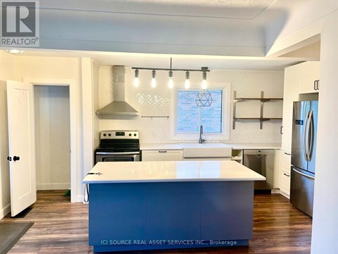 A kitchen with a white island and a stainless steel dishwasher.