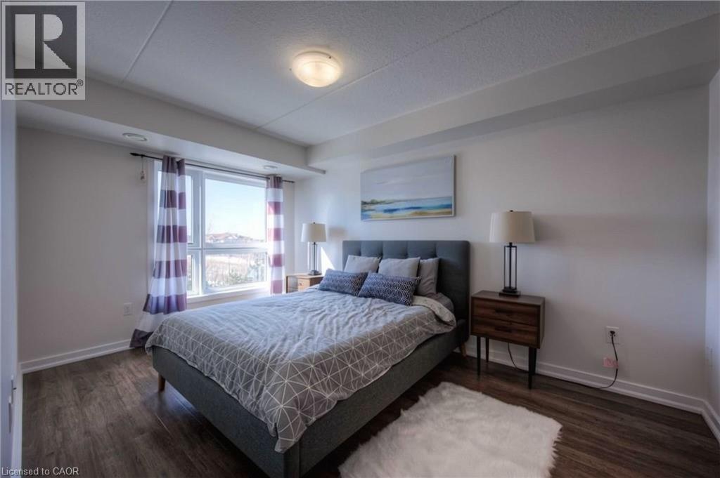 A bedroom with a large bed and a window with curtains.