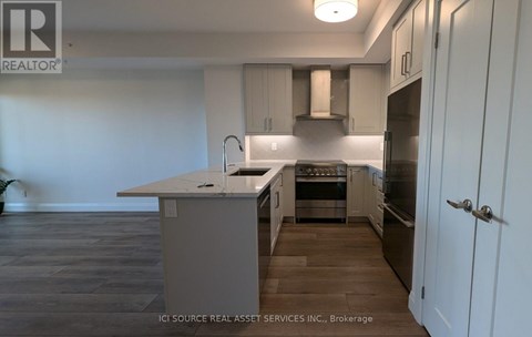 A kitchen with a white counter top and stainless steel appliances.