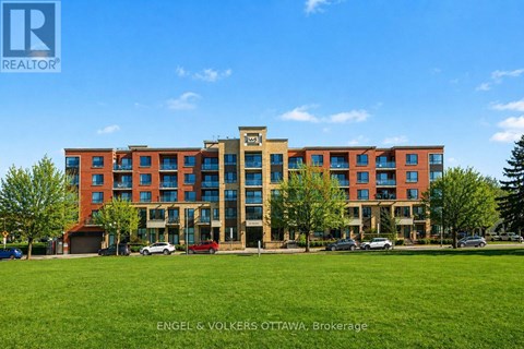 A large multi-story building with a grassy area in front.