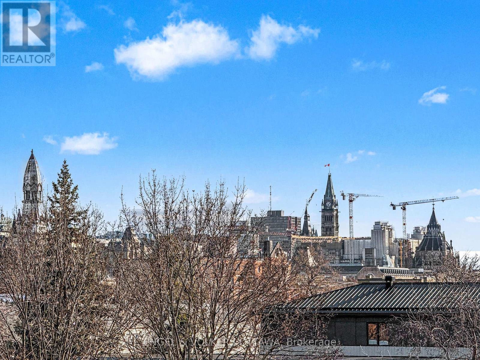 A balcony with a black railing overlooks a cityscape.