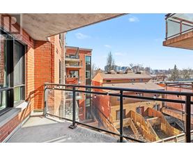 A balcony with a black railing overlooks a cityscape.