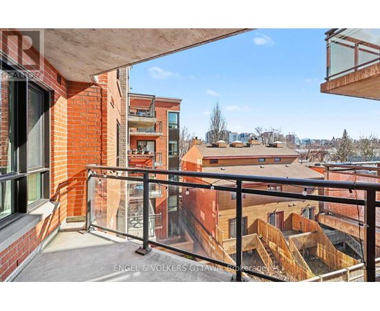 A balcony with a black railing overlooks a cityscape.