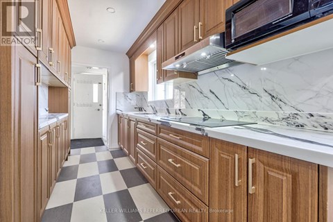 A kitchen with wooden cabinets and a checkered floor.