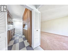 A kitchen with a checkered floor and wooden cabinets.