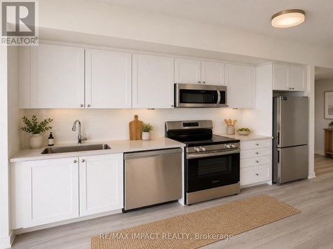 A modern kitchen with white cabinets and stainless steel appliances.