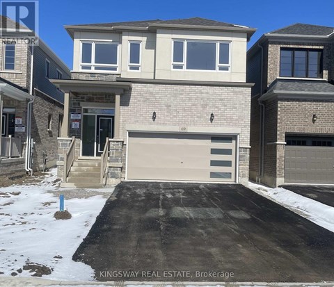 A house with a garage and a driveway in front of it.