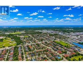 A bird's eye view of a residential area with houses and green spaces.