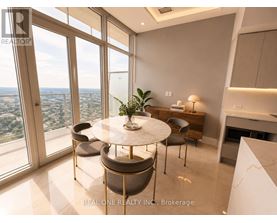 A dining room with a table and chairs with a view of the city.