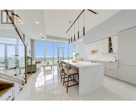 A modern kitchen with white cabinets and a marble island.